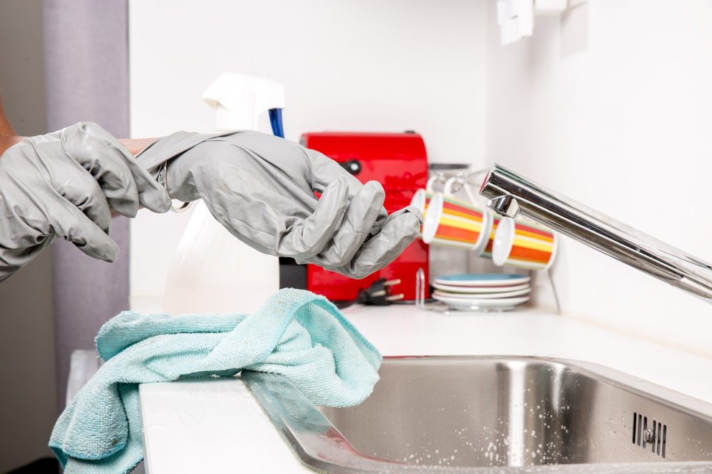 personne qui enfile des gants a coté de son lavabo