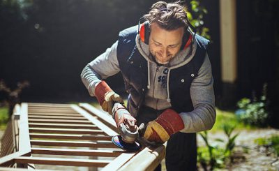 Bricoleur qui utilise une ponceuse électrique en portant un casque anti-bruit