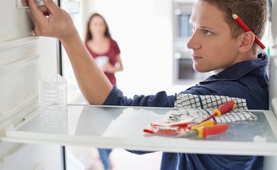 Homme qui répare l'intérieur d'un réfrégérateur