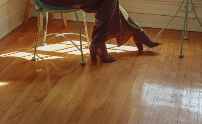 Une femme en talons sur du parquet en bois clair